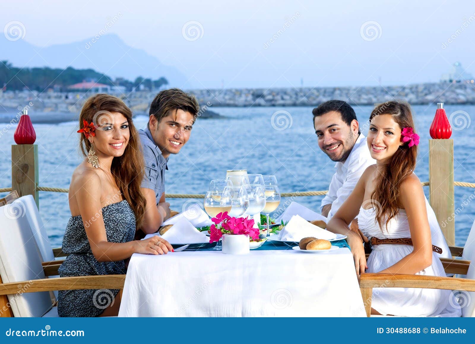 two happy couples having dinner at the seaside