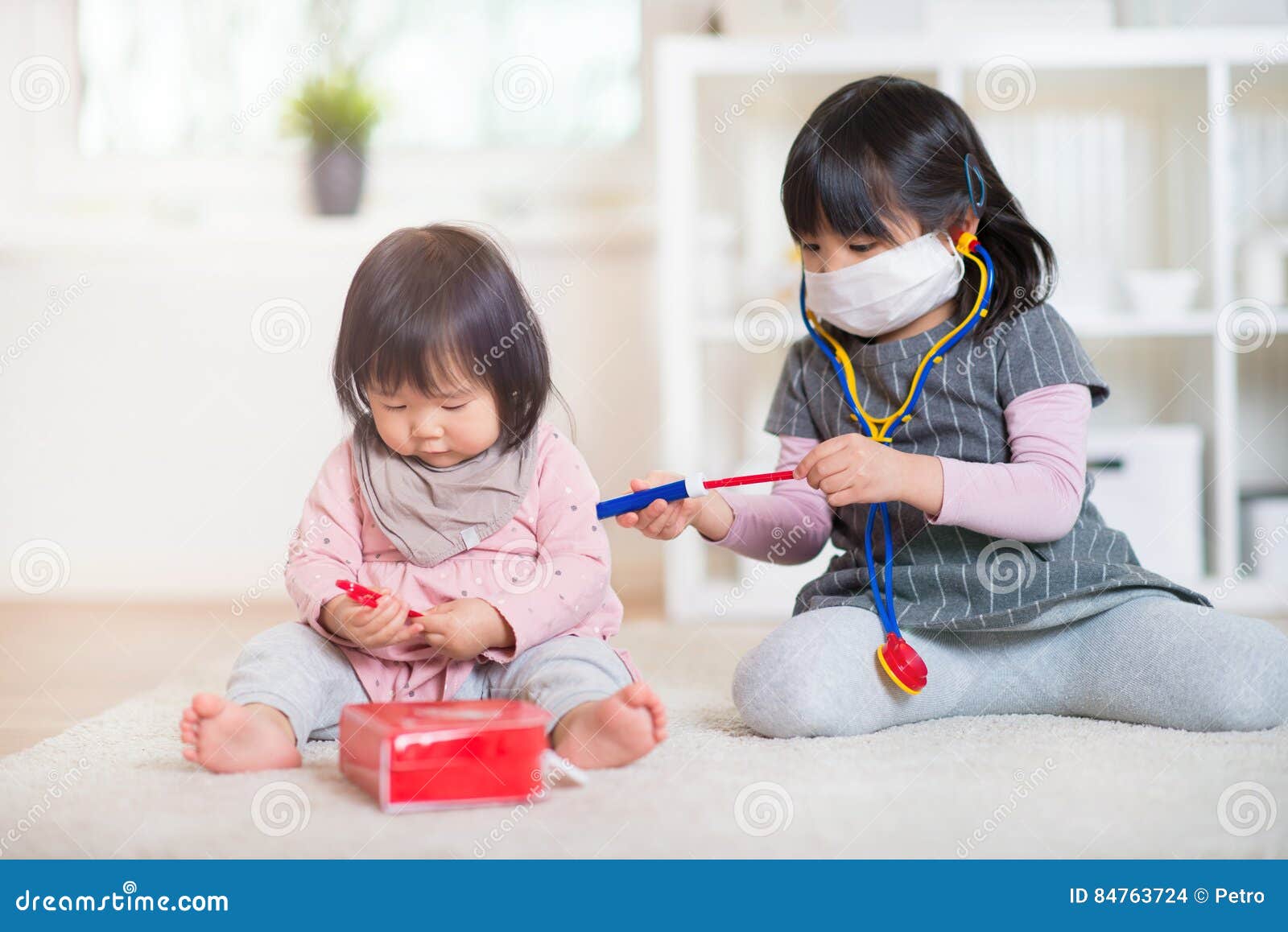 Two Happy Japanese Sisters Playing With Medical Set At Home Stock