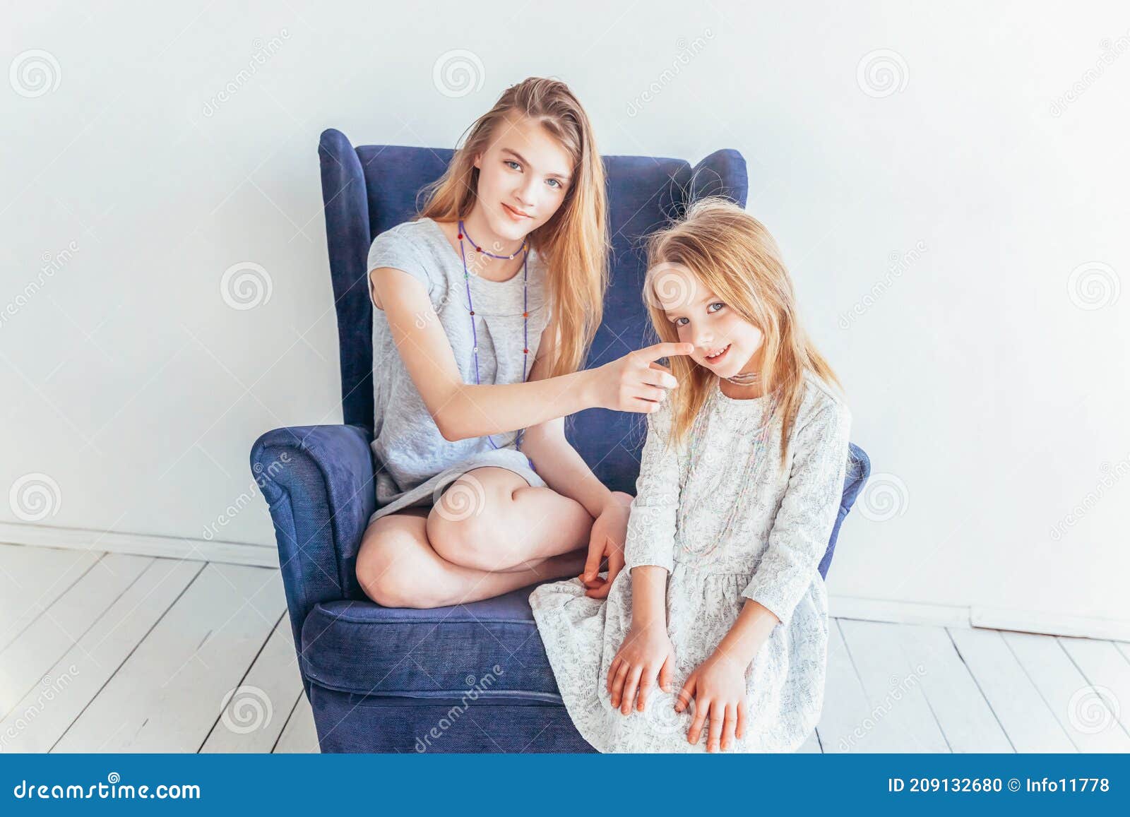 Two Happy Kids Sitting on Cozy Blue Chair Relaxing Playing in White ...