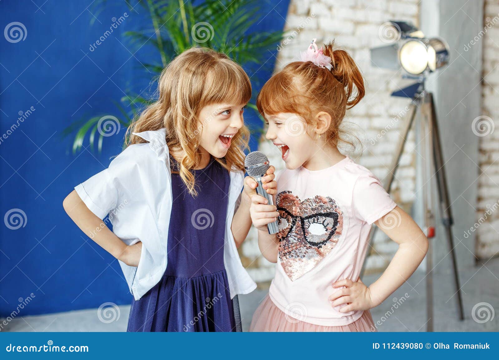 two happy little children sing a song in karaoke. the concept is