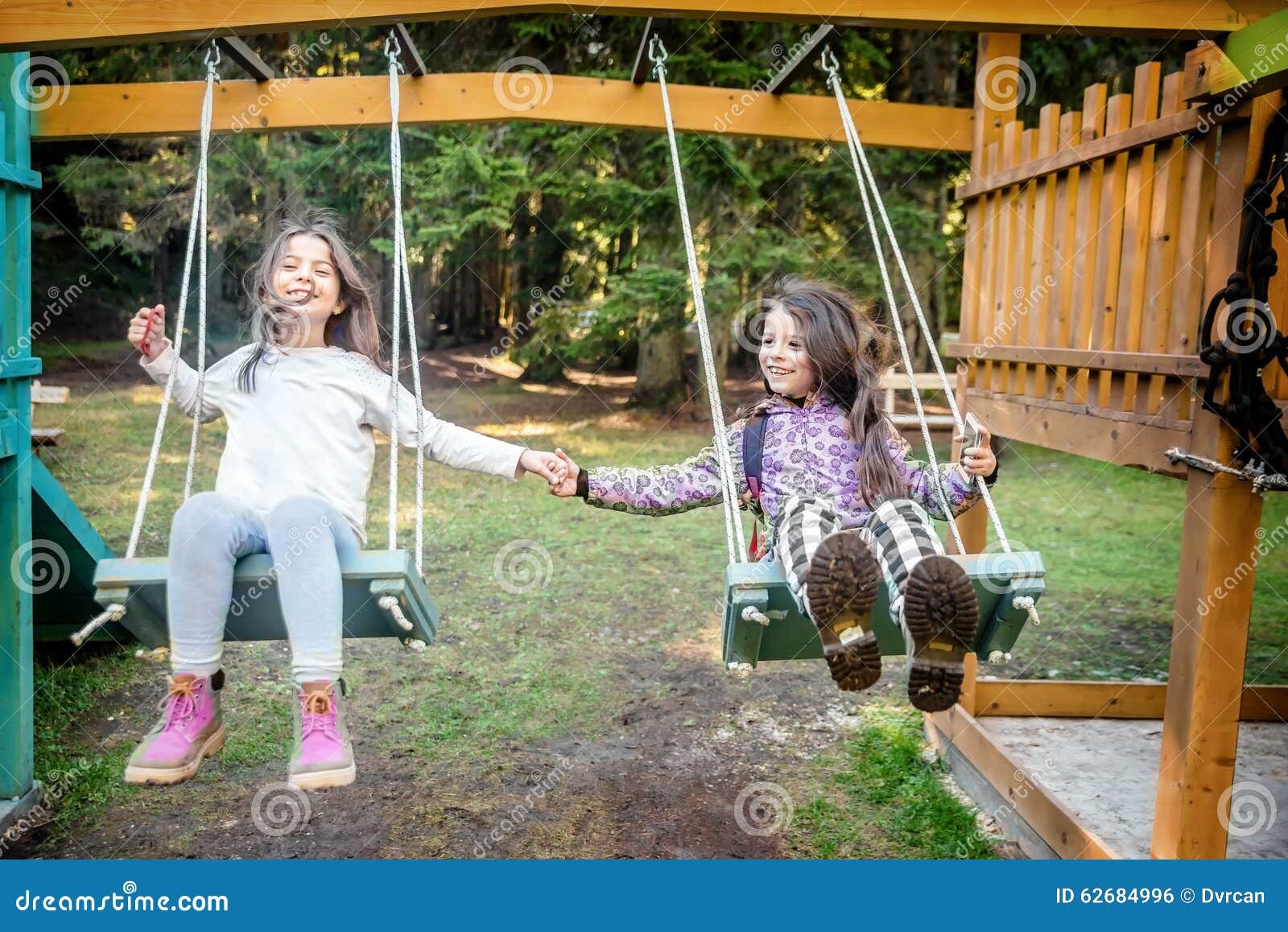 Two Happy Little Girls Swinging on the Swing Stock Photo - Image of ...