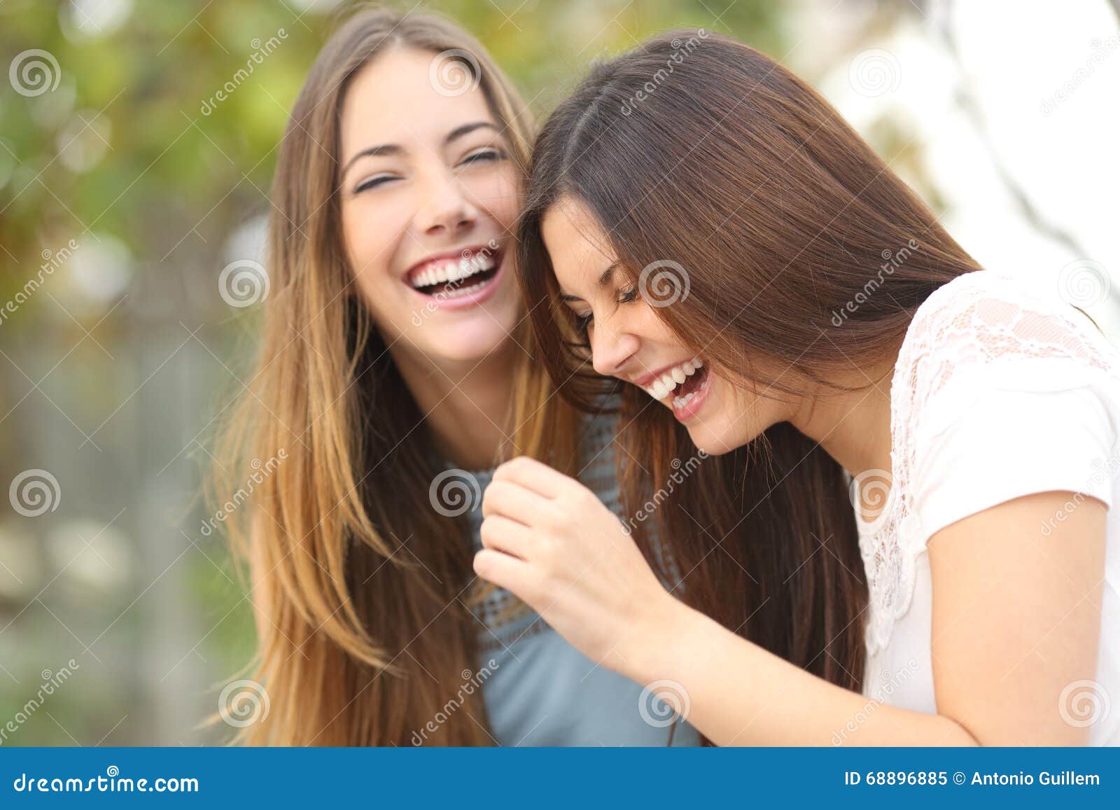 two happy woman friends laughing