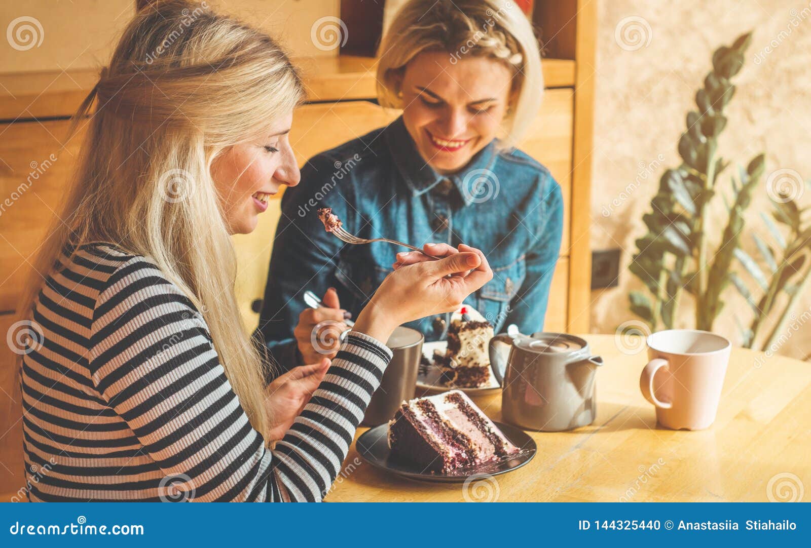 Two Happy Women Sitting in a Cafe, Drink a Hot Tea, Tell Each Other Funny  Stories, Being in a Good Mood, Laughing Happily Stock Photo - Image of  house, funny: 144325440