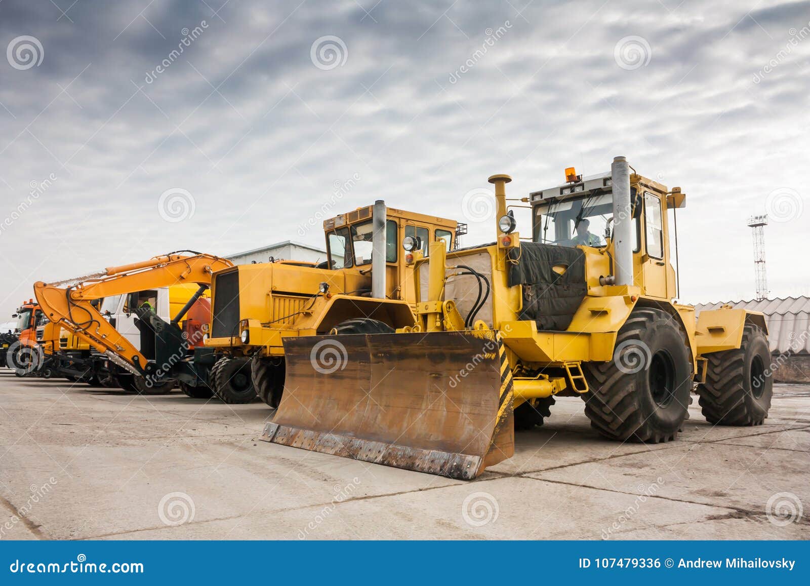 two heavy wheeled tractor one excavator and other construction machinery