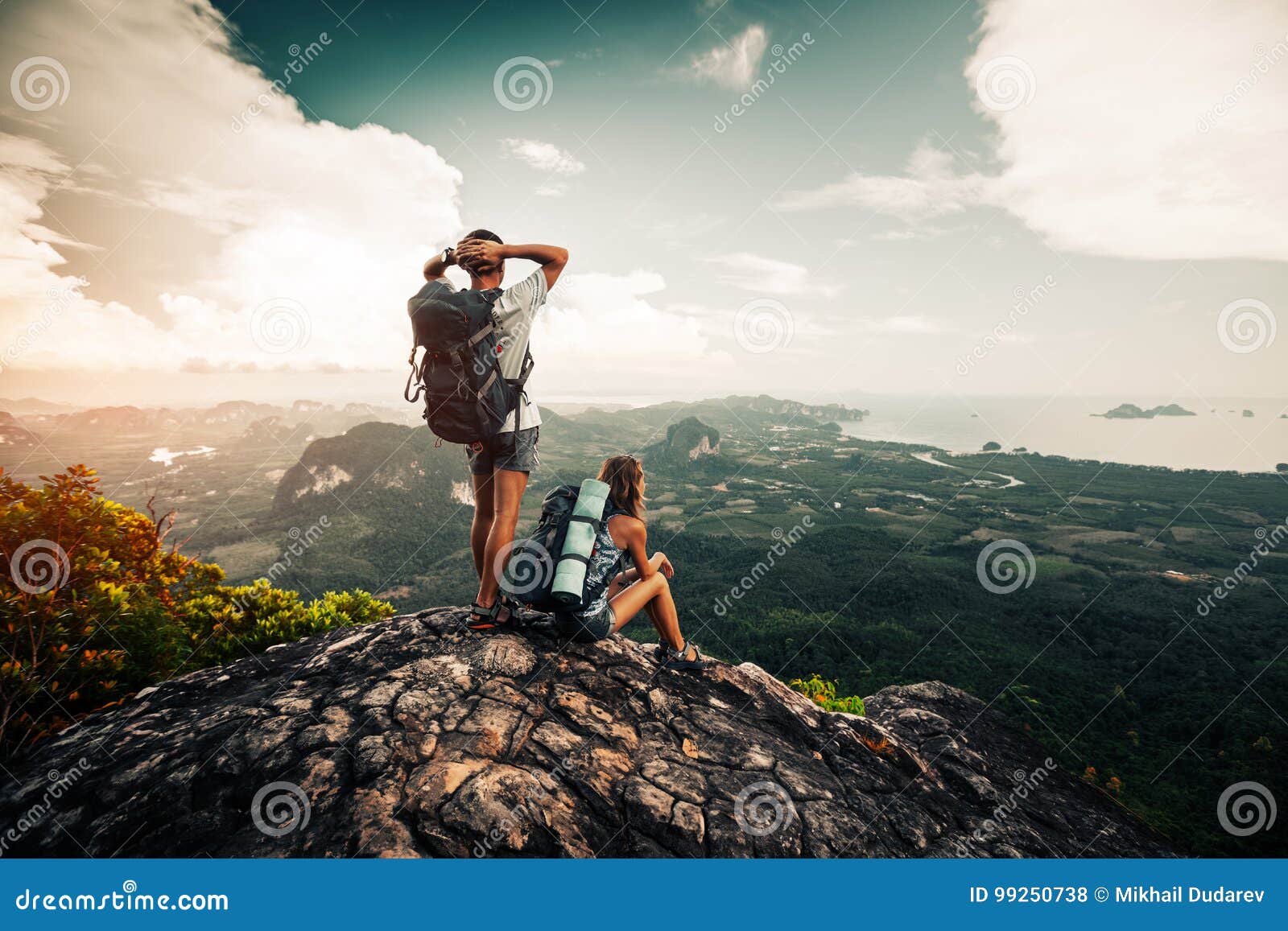 two hikers relax on top of a mountain