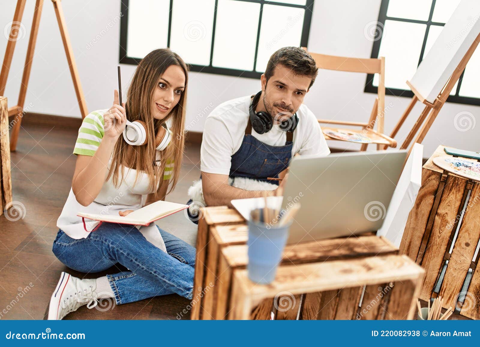 Two Hispanic Students Having Online Paint Class Using Laptop at Art