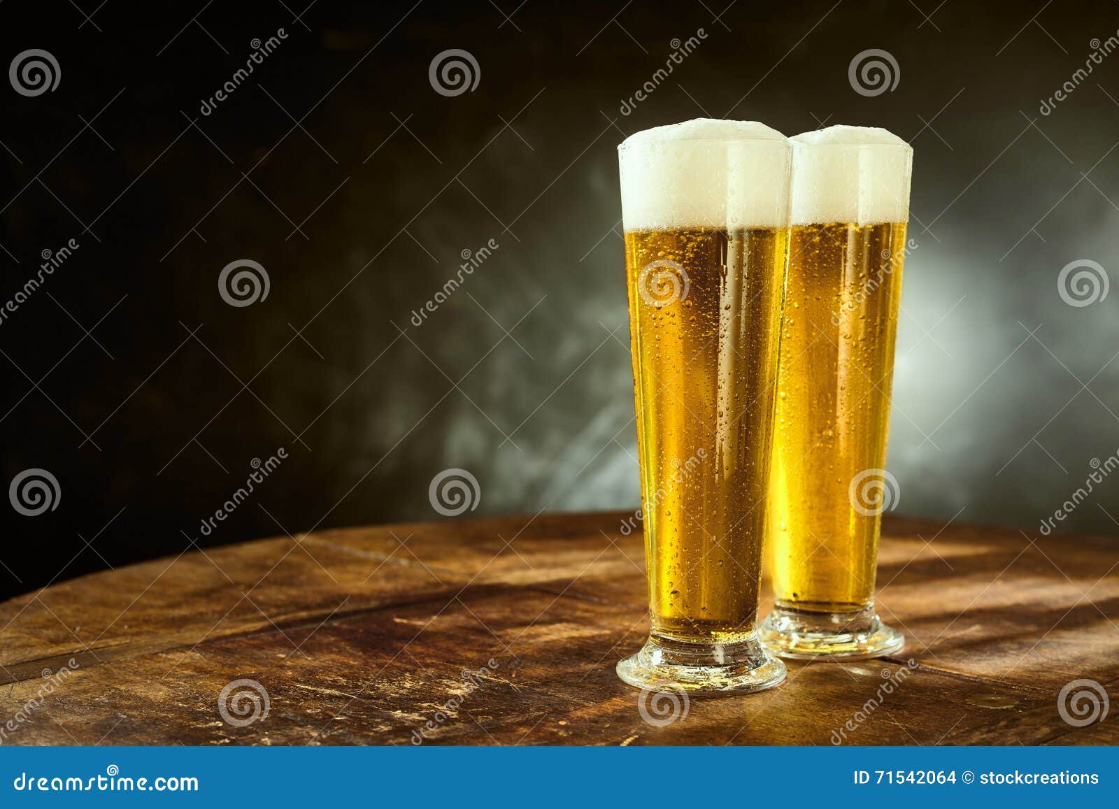 two ice cold frothy beers in elegant long glasses