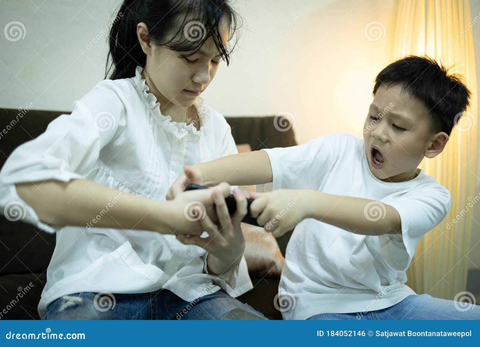 two kids boy and child girl fighting for smartphone,sibling pulling mobile phone one another,shout and quarrel,children arguing