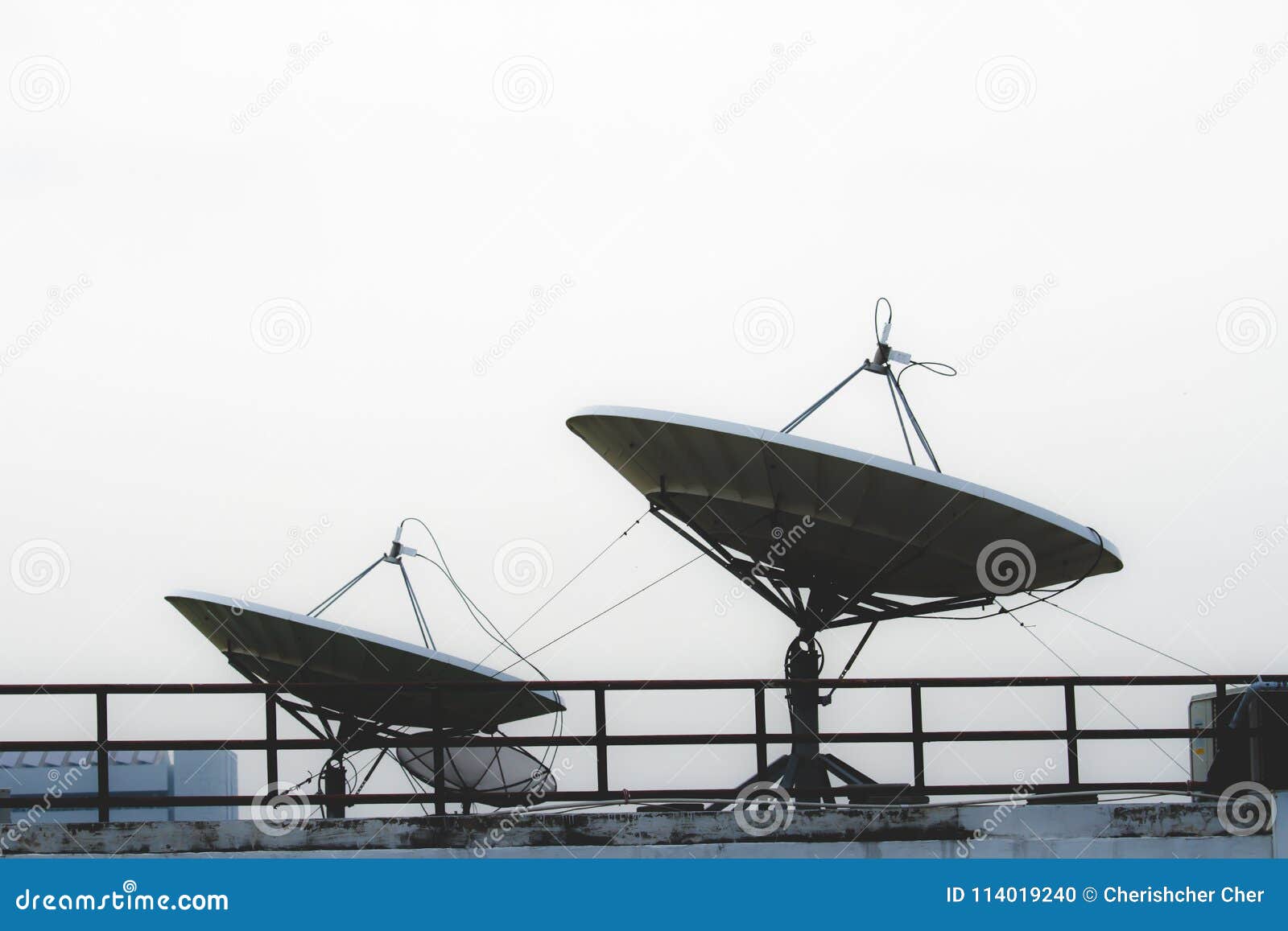 Two Large Satellite Dishes at the Top of the Building. Stock Photo