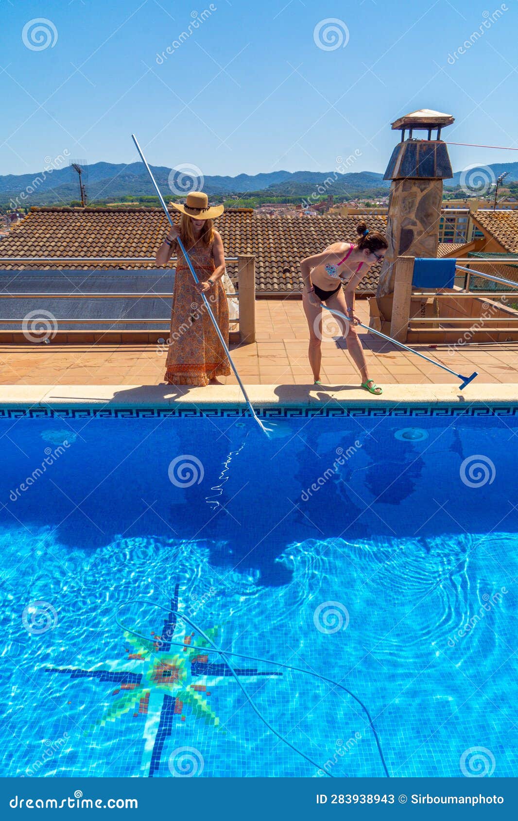 Two Lesbian Couple Friends Smiling and Cleaning a Swimming Pool