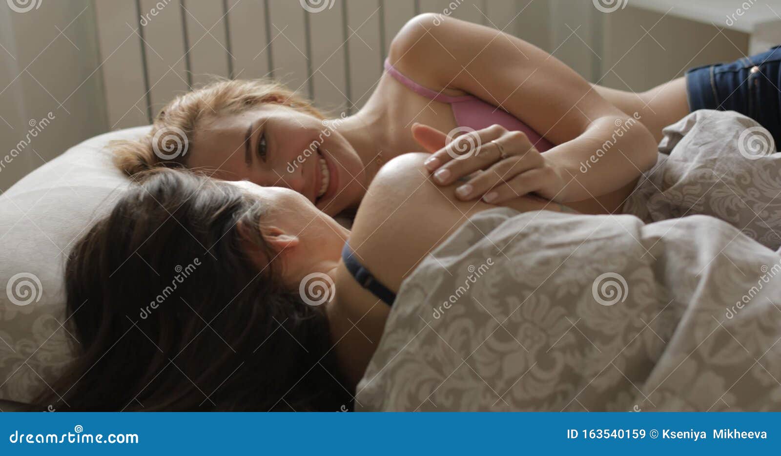 2 beautiful lesbian loving french kissing on the bed