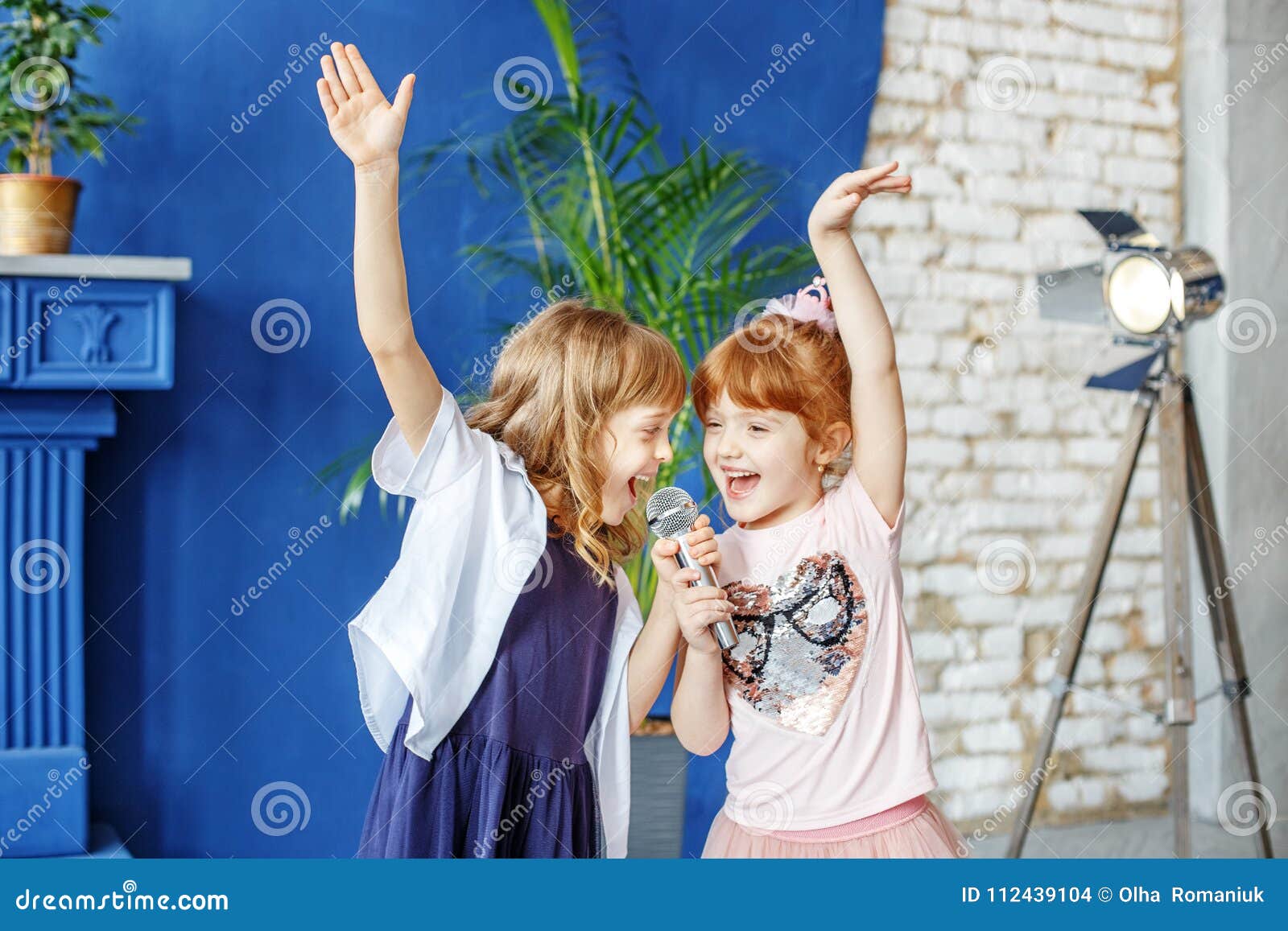 two little funny children dance and sing a song in karaoke. the