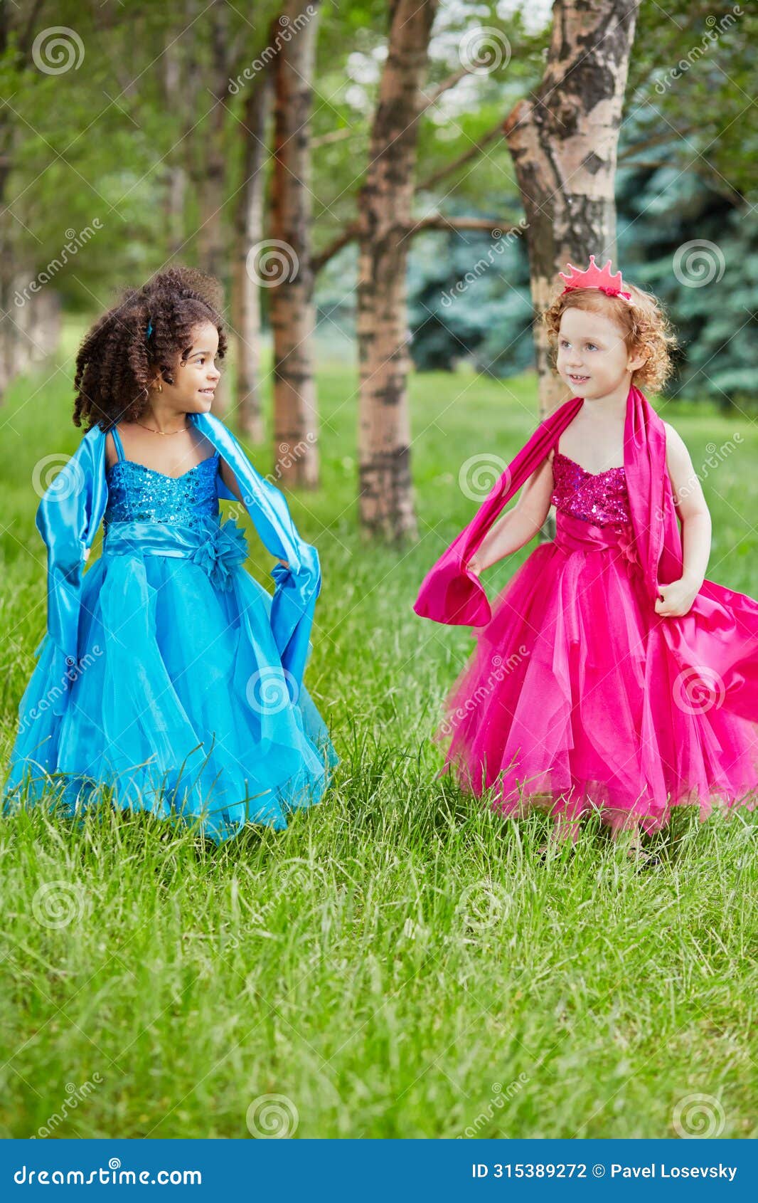 two little girls in beautiful puffy gowns perform
