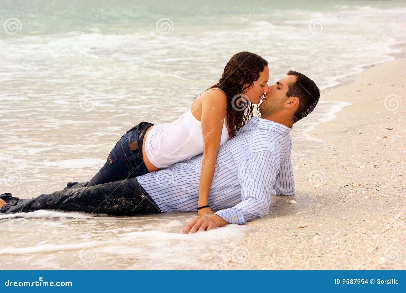 two lovers kissing at waters edge