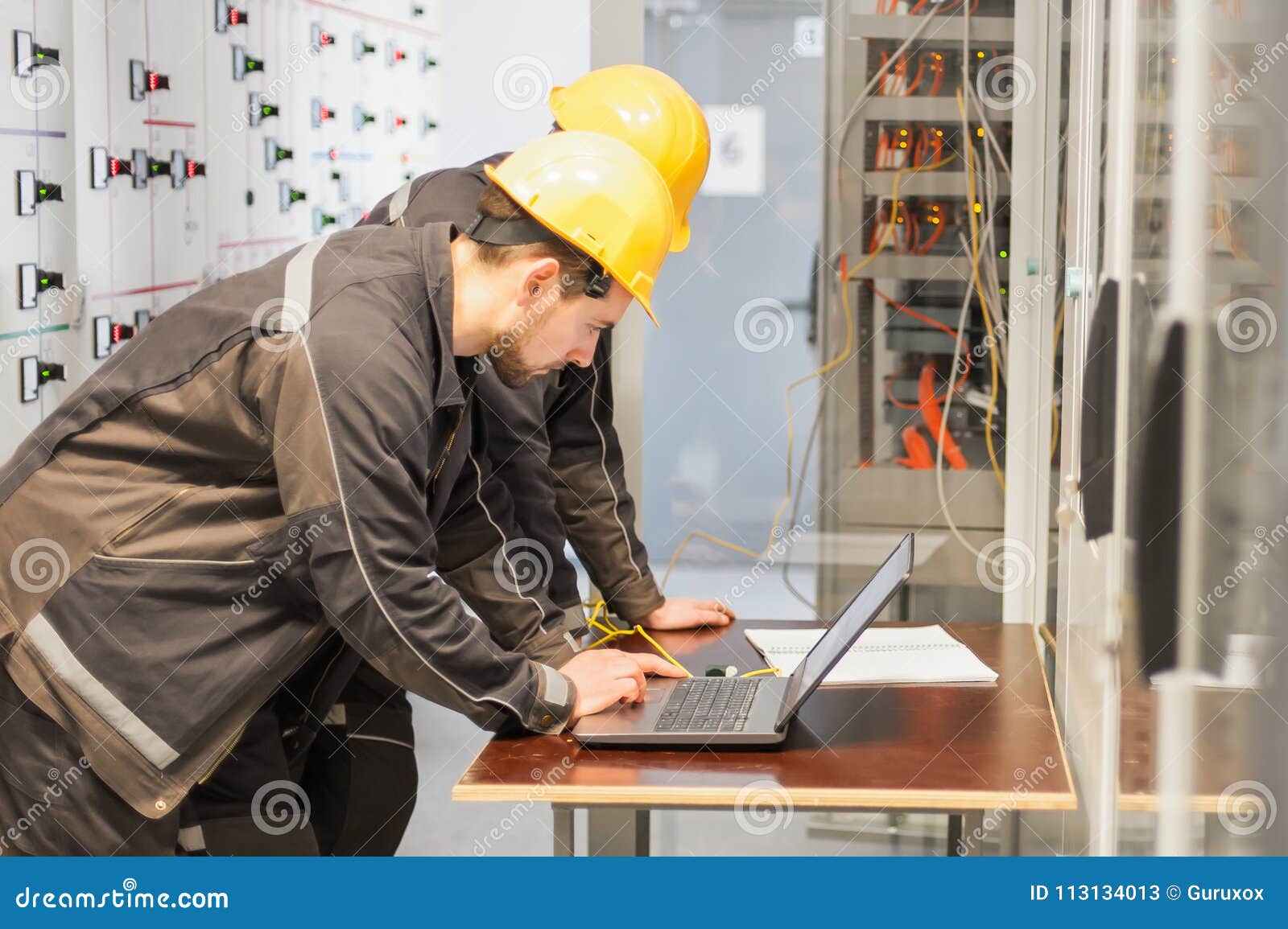 Two Maintenance Engineers Inspect Relay Protection System with L Stock