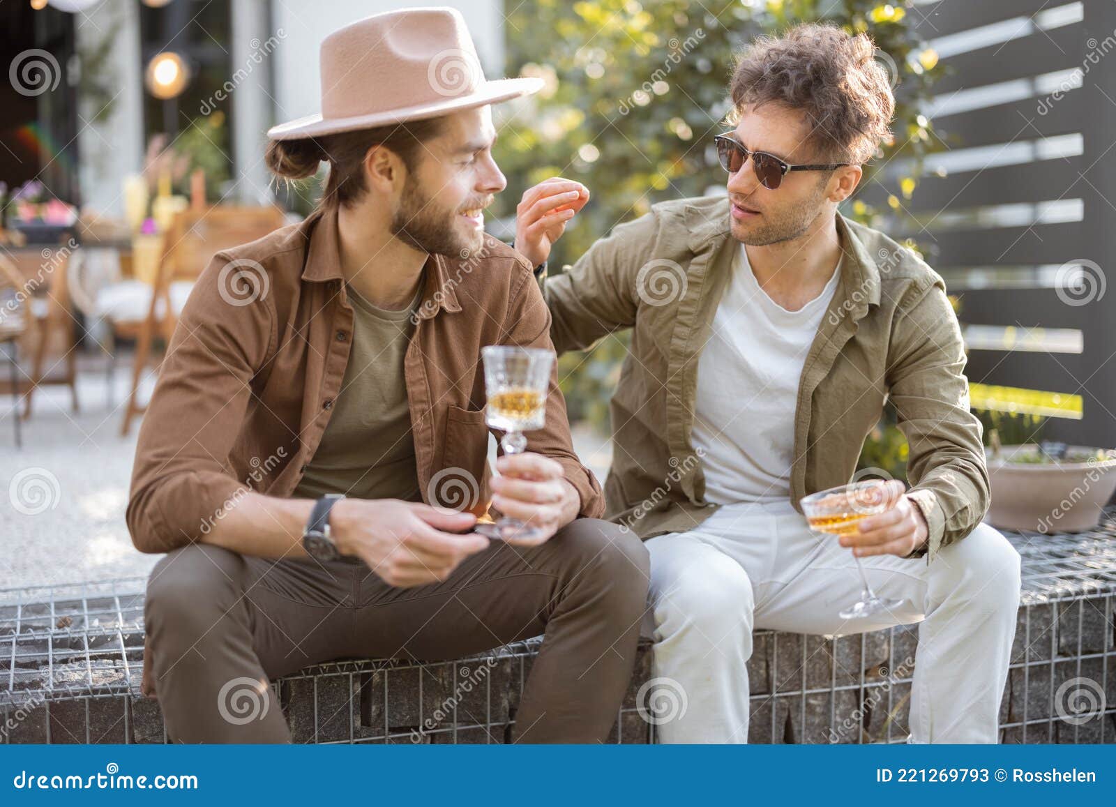 two male friends talking on a porch of the country house