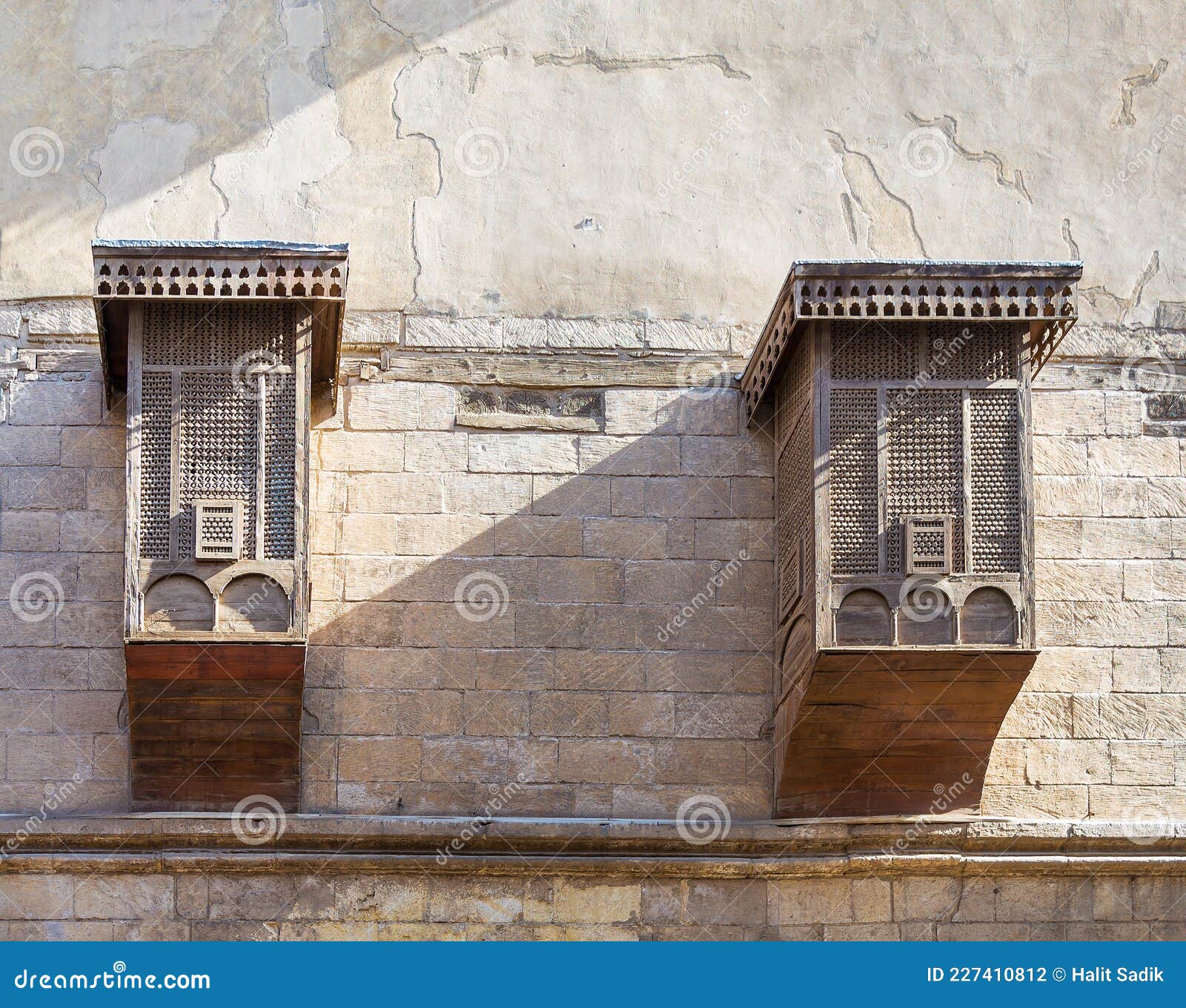 mamluk era style oriel windows with interleaved wooden grid - mashrabiya, on shabby wall, cairo