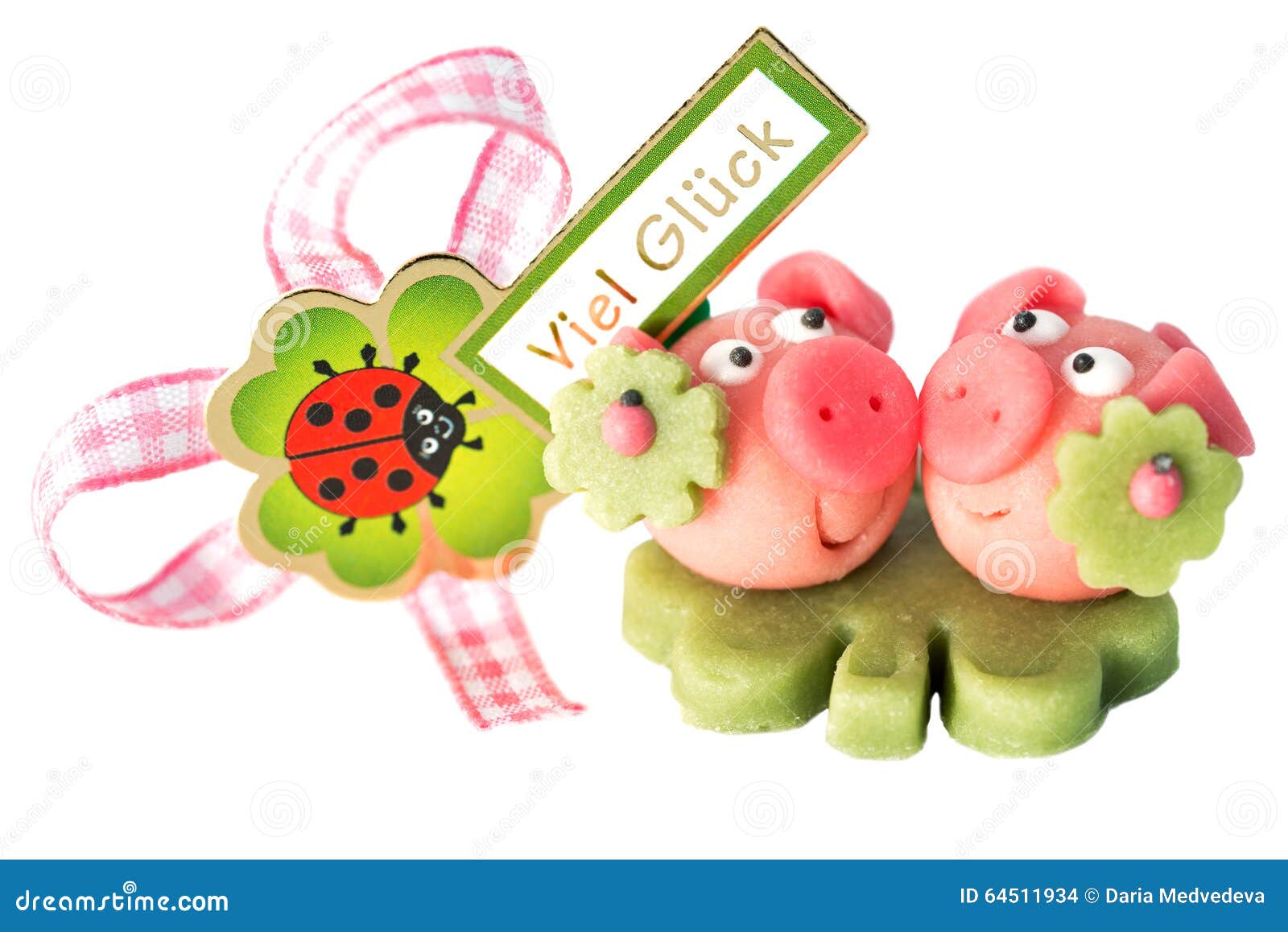 two marzipan pigs with cloverleaf and good luck (in german) written on a background