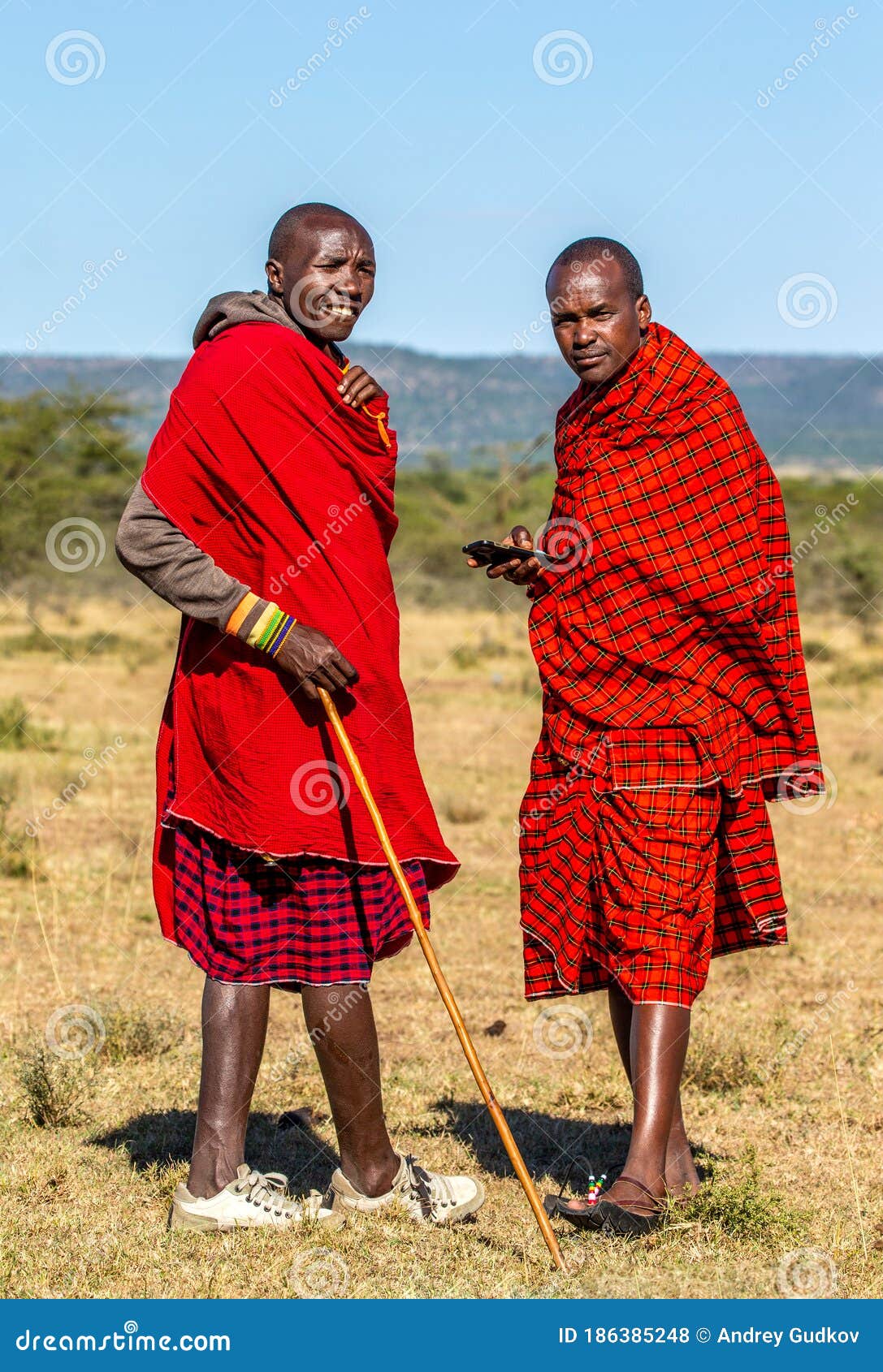 Two Masai Men Stand in the Savannah in Traditional Clothing. Editorial ...