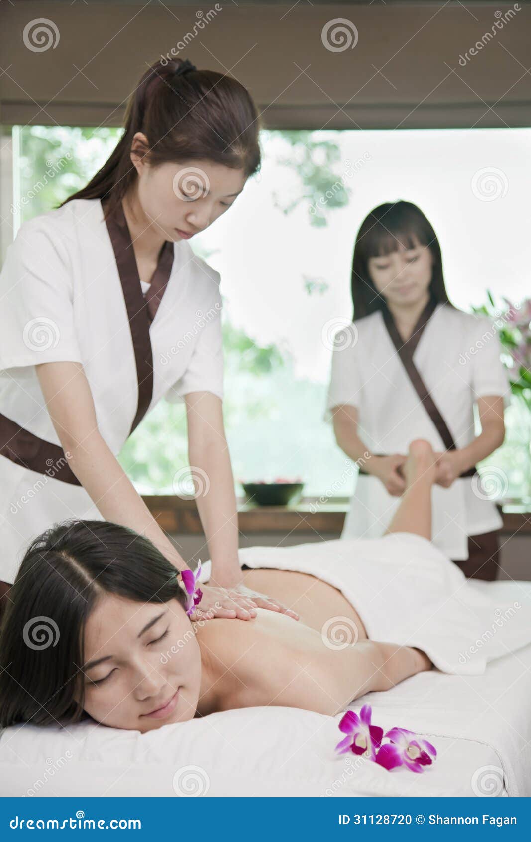 Two Masseuses Massaging One S