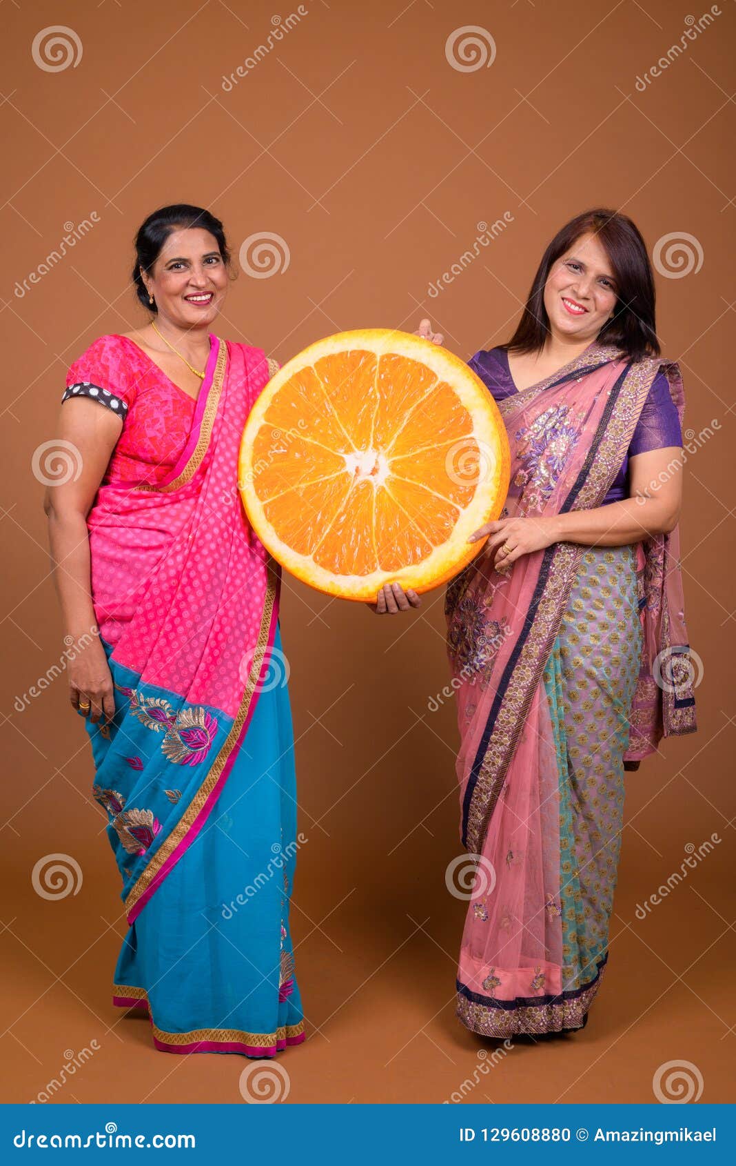 Two Mature Indian Women Holding Big Slice of Orange Fruit Stock Photo -  Image of female, happy: 129608880