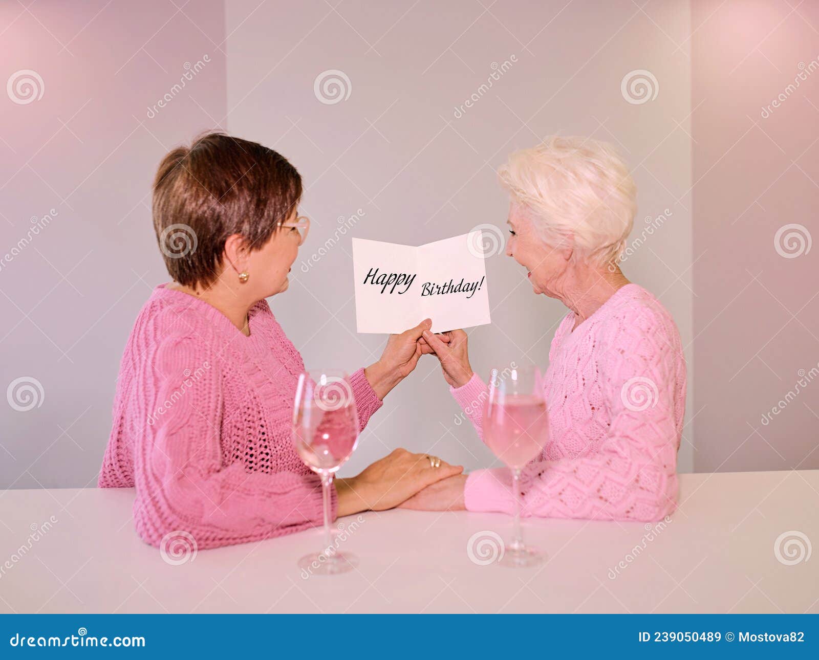 Two Mature Women Drinking Wine and Giving a Post Card