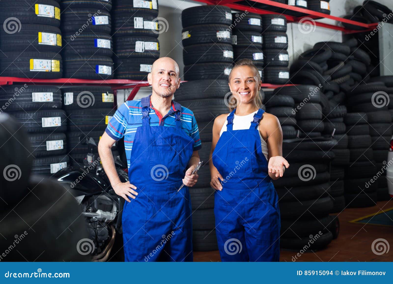 Two mechanics in car fixing workshop. Two smiling mechanics standing together in car fixing workshop