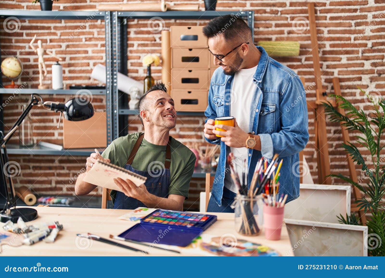 Two Men Artists Drawing on Notebook Drinking Coffee at Art Studio Stock