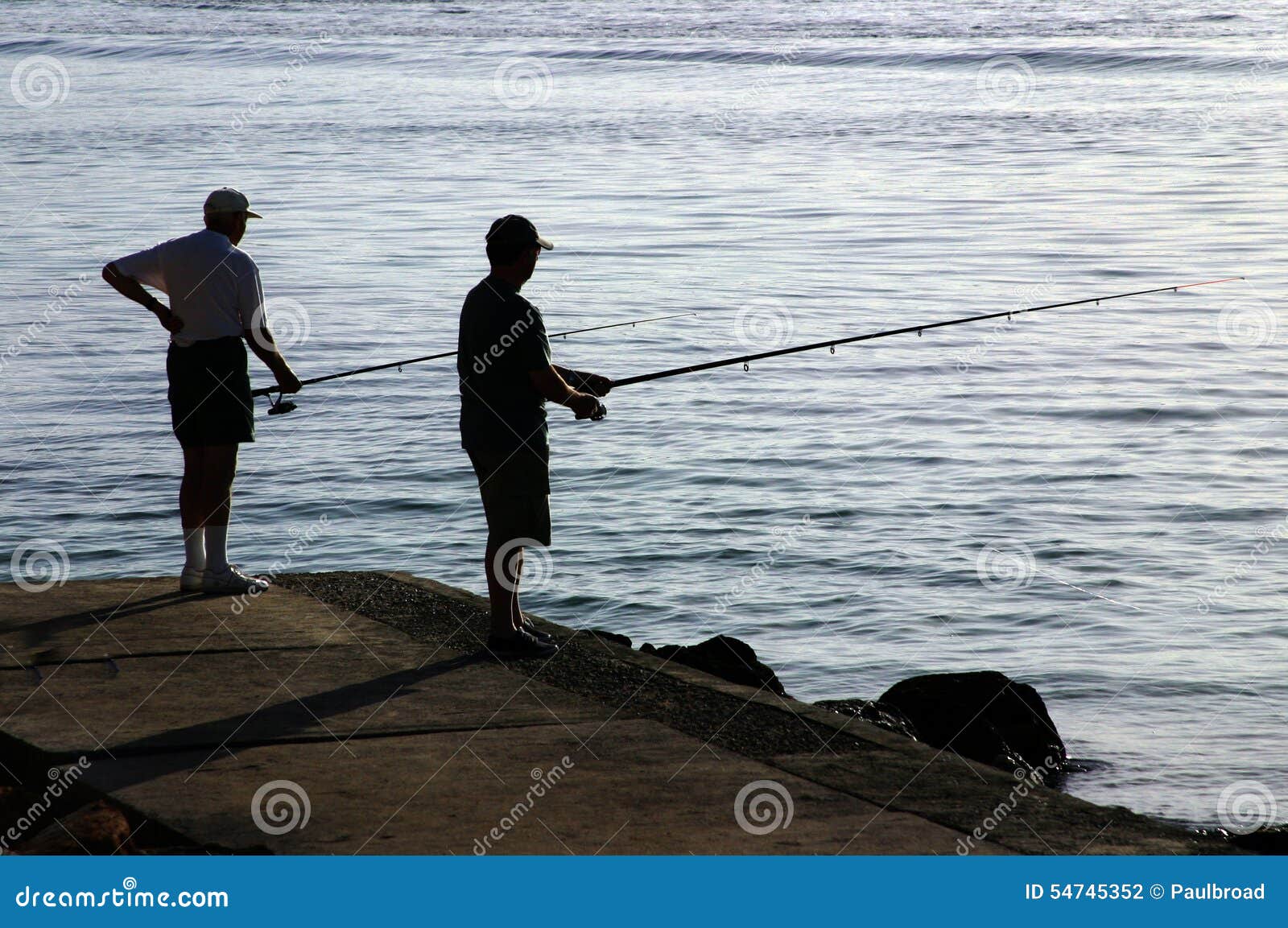 Two men fishing in the sea. Two men fishing in the sea on holiday in Majorca.