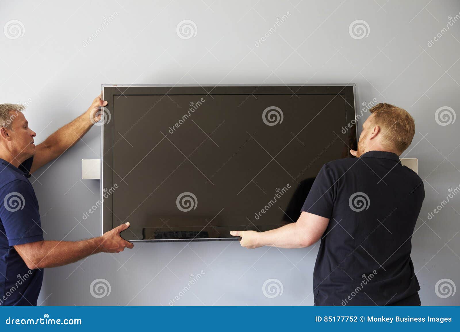 Two Men Fitting Flat Screen Television To Wall Stock Photo Image of