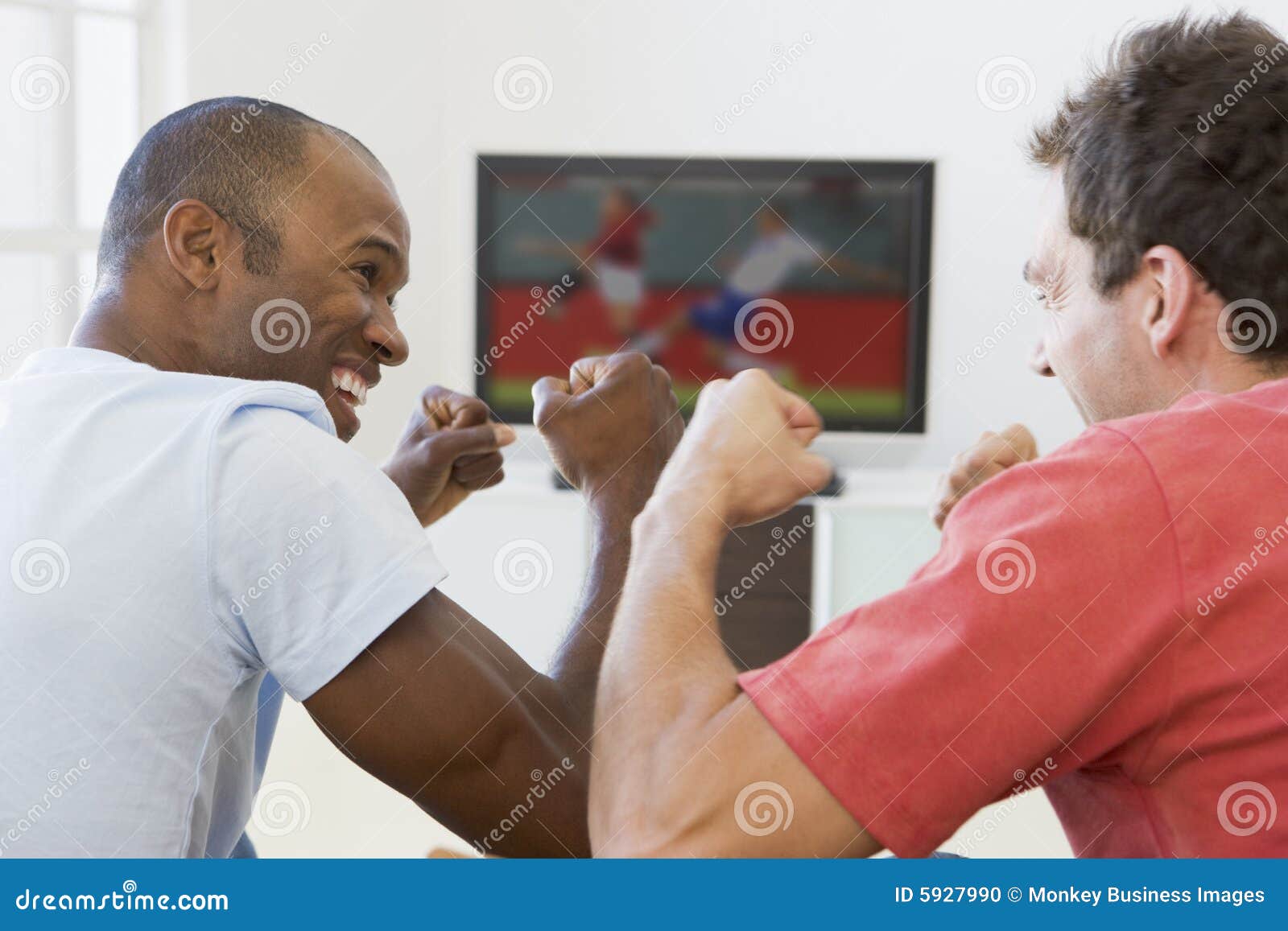 two men in living room watching television