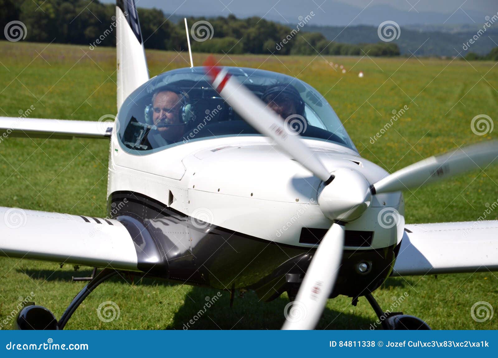 Ocova, Slovakia - August 2, 2014: Two men sit into ultralight propeller-driven airplane and get ready for taking off