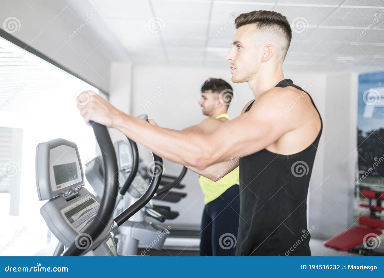 Two Men Training in Elliptical Bike Stock Photo Image of attractive