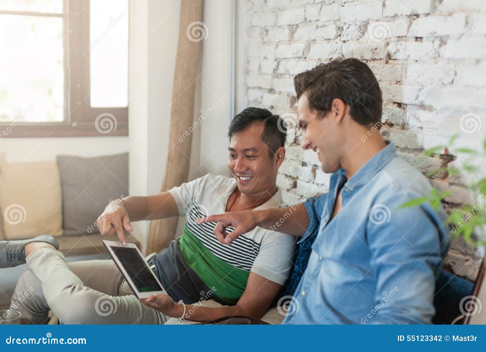 Friends Using Laptop On Sofa Mixed Race Typing Having Photo