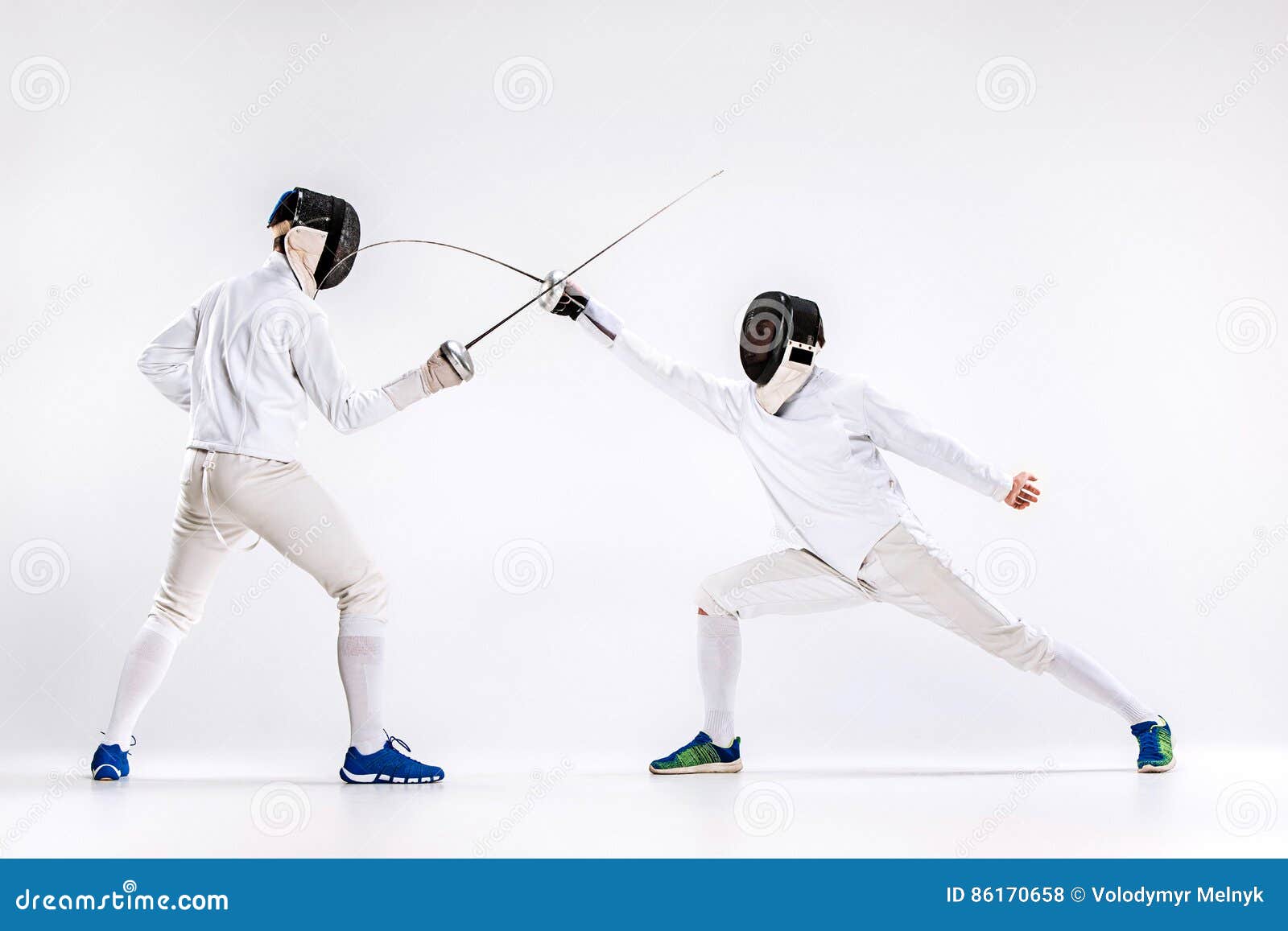 the two men wearing fencing suit practicing with sword against gray