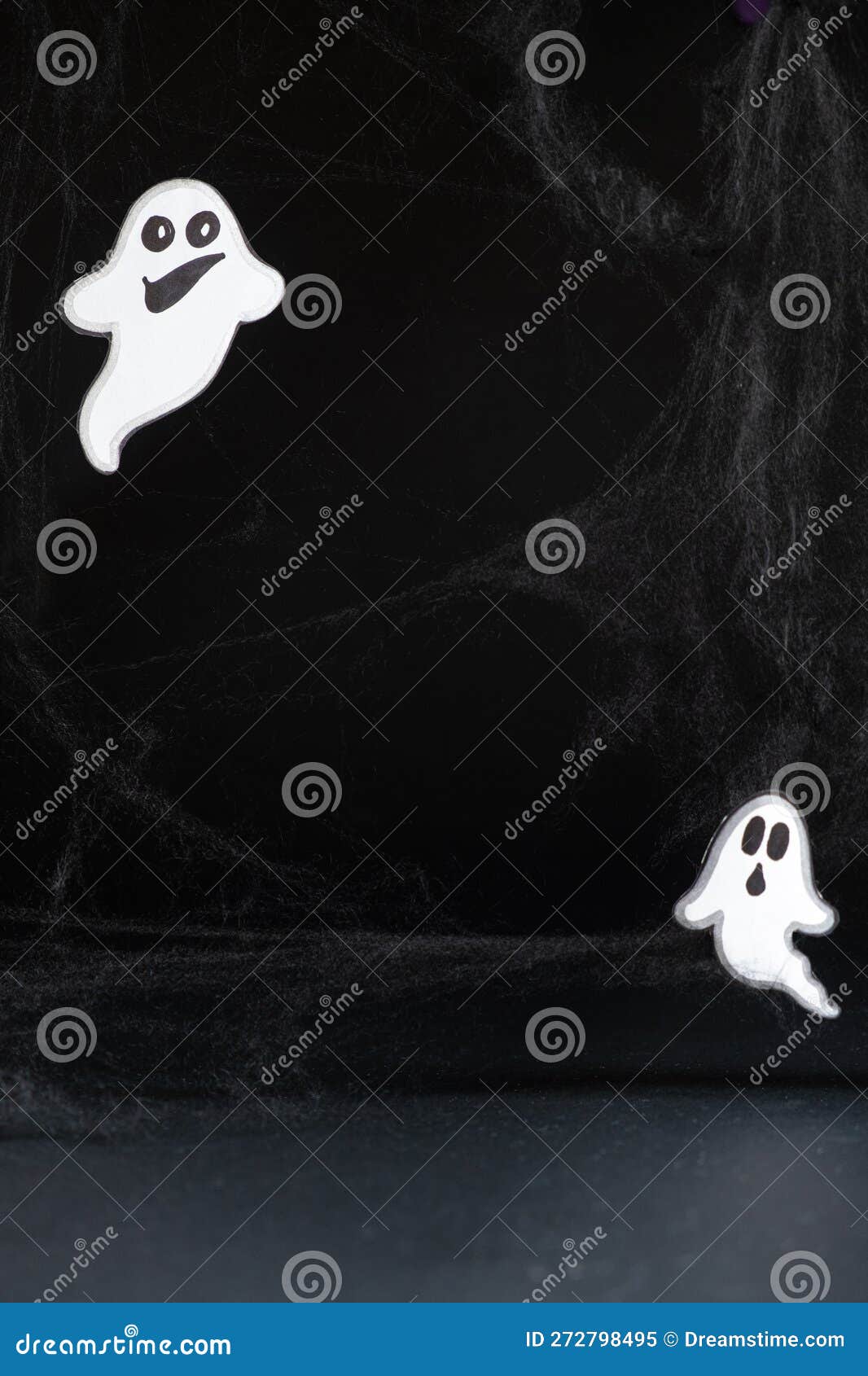 two merry ghosts with faces fly and smile on a black background with a web. halloween card, a place for text