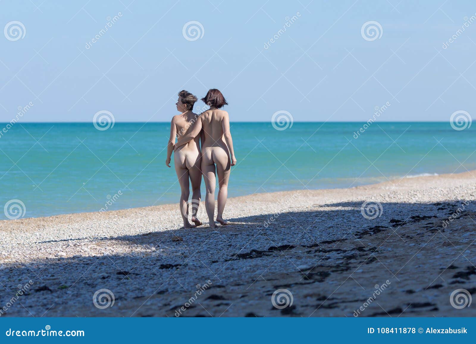 Two Nude Female Persons Going Along Seashore in Morning Time Stock Photo photo