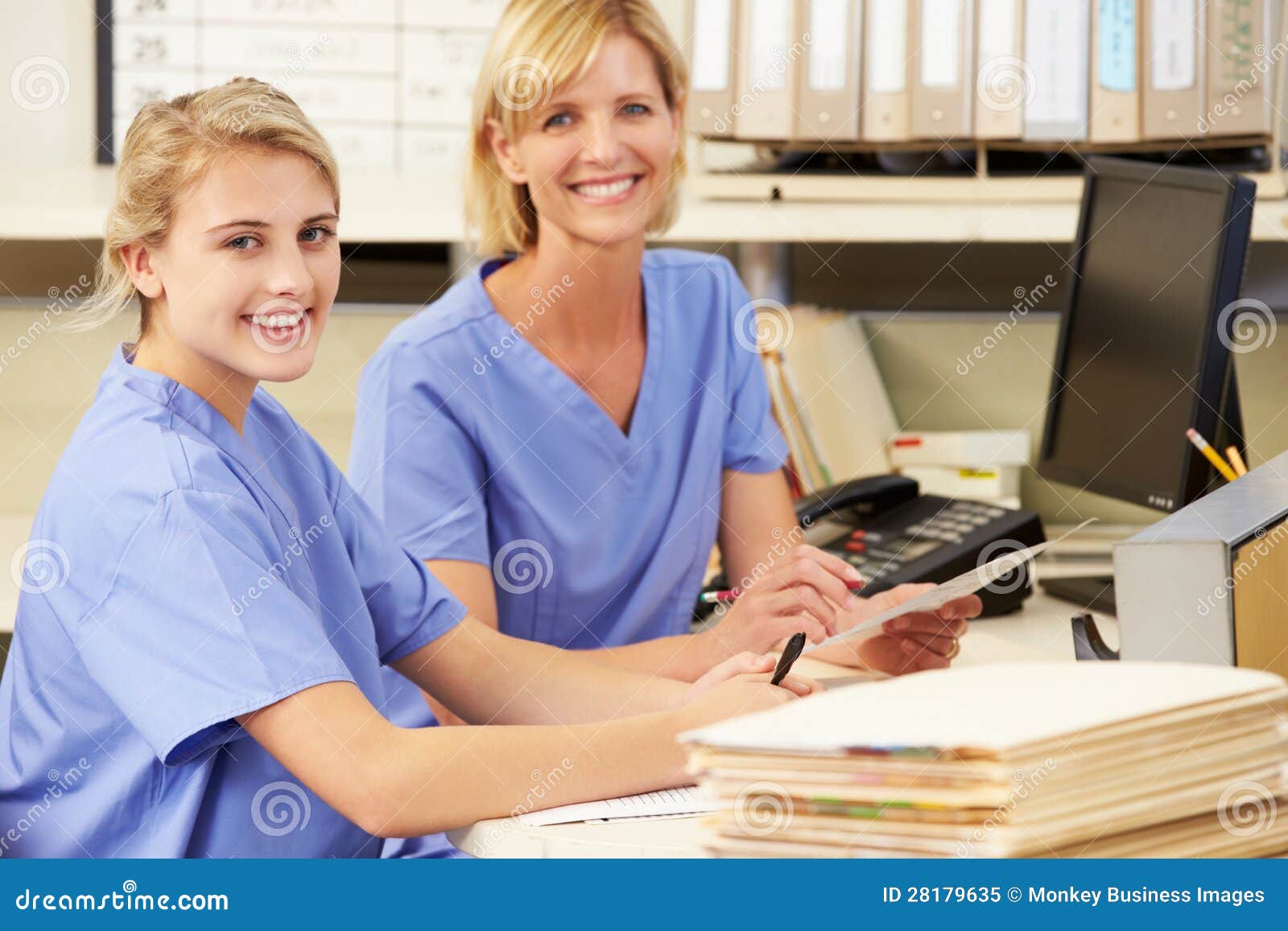 two nurses working at nurses station