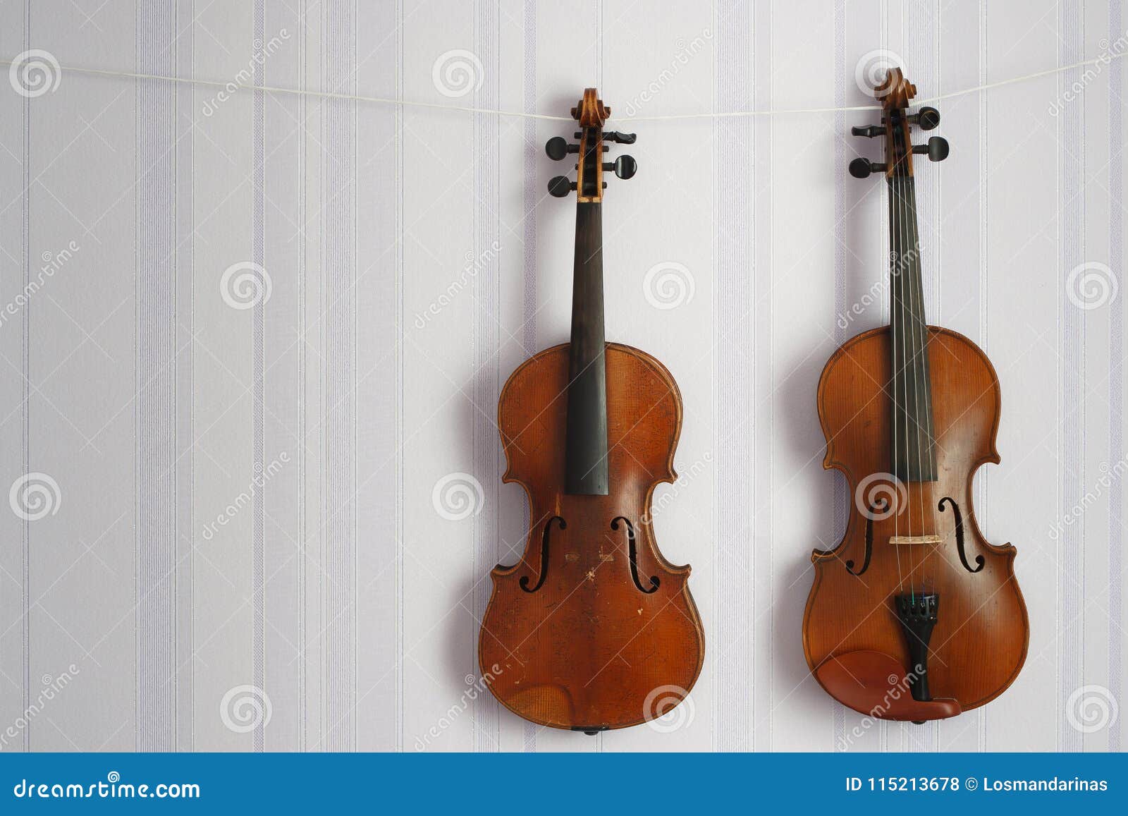 Two Old Violins of the Same Size Hanging on the Wall with Copy Space
