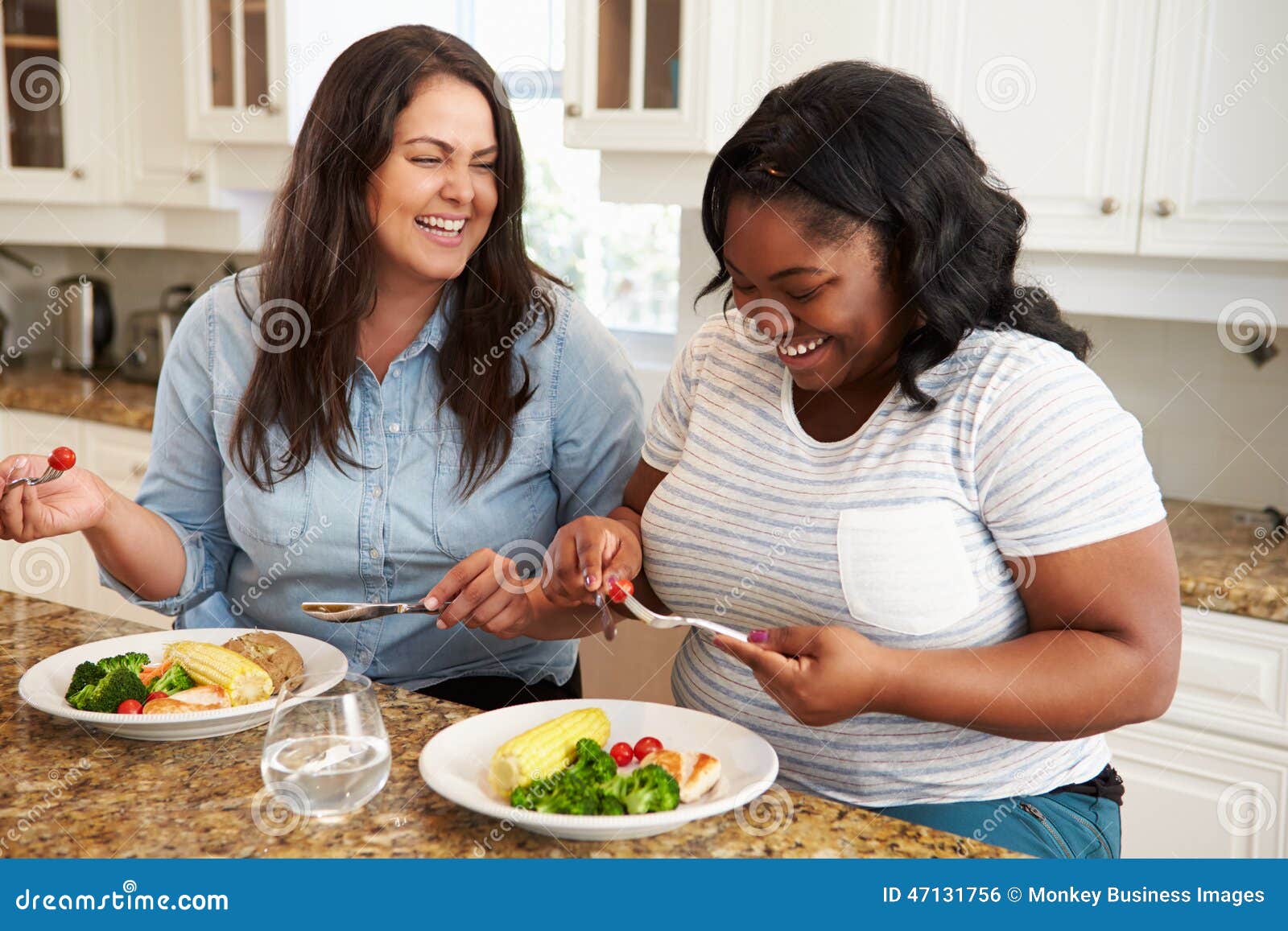 two overweight women on diet eating healthy meal in kitchen