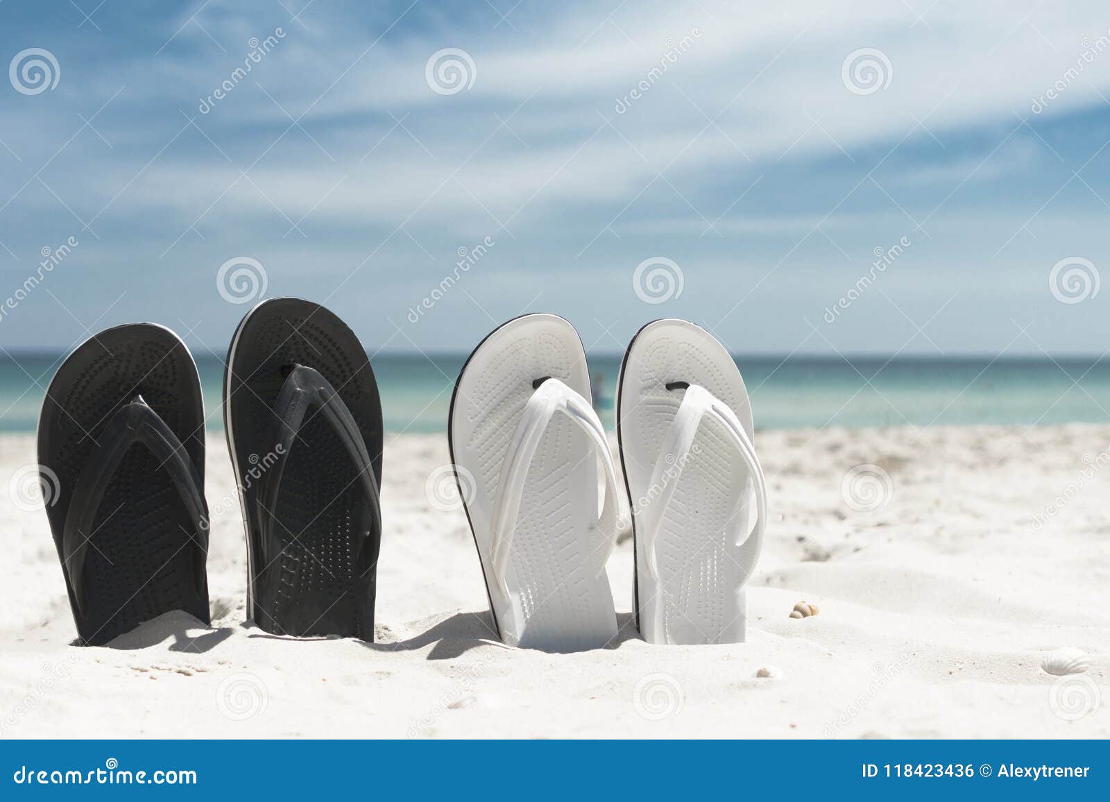 Two Pair of White and Blackn Flip-flops in the Sand. Summer Vacation