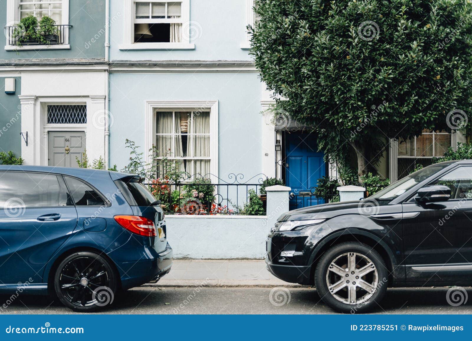 two parked cars in front of an apartment entrance