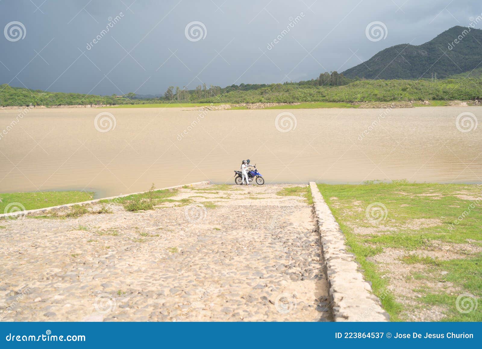 two people with their motorcycle on the corrinchis dam in mascota jalisco.