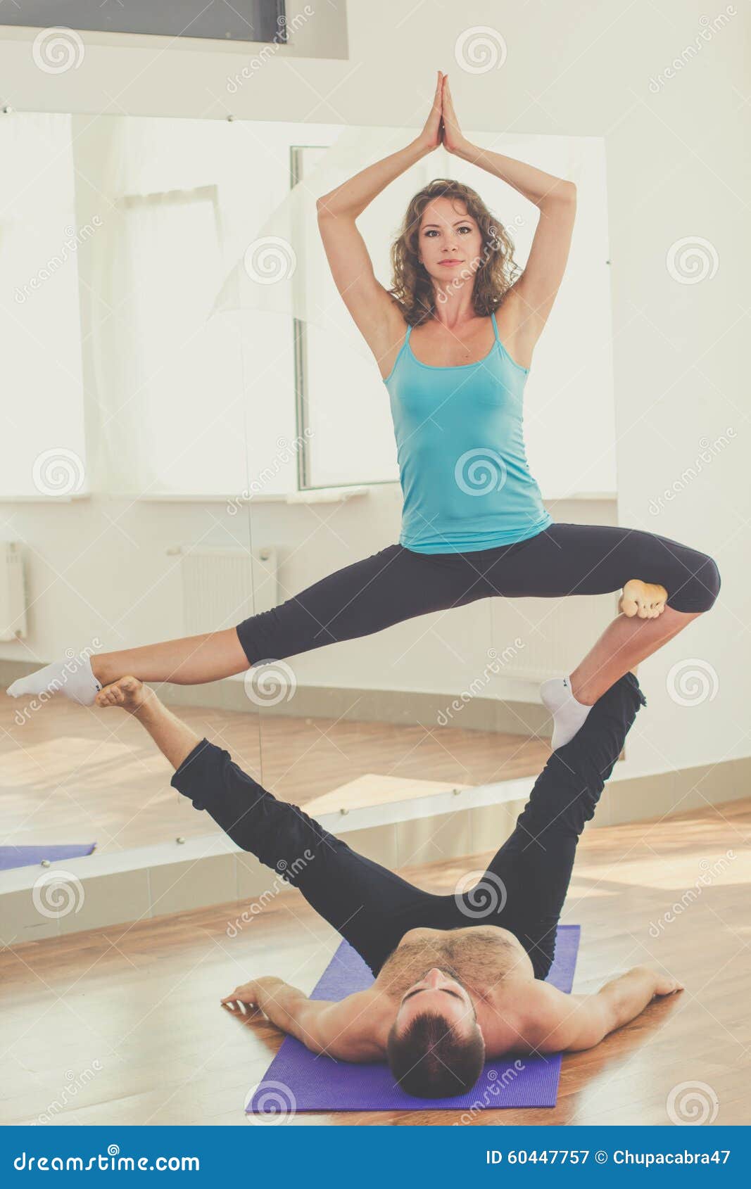 Two athletes performing duo acroyoga poses Stock Photo by Photology75