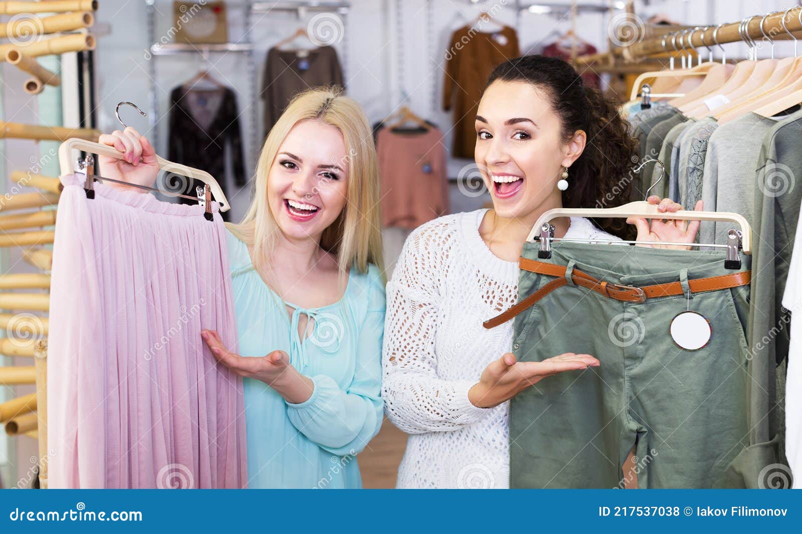 Two girls choosing clothes stock photo. Image of girlfriends - 217537038