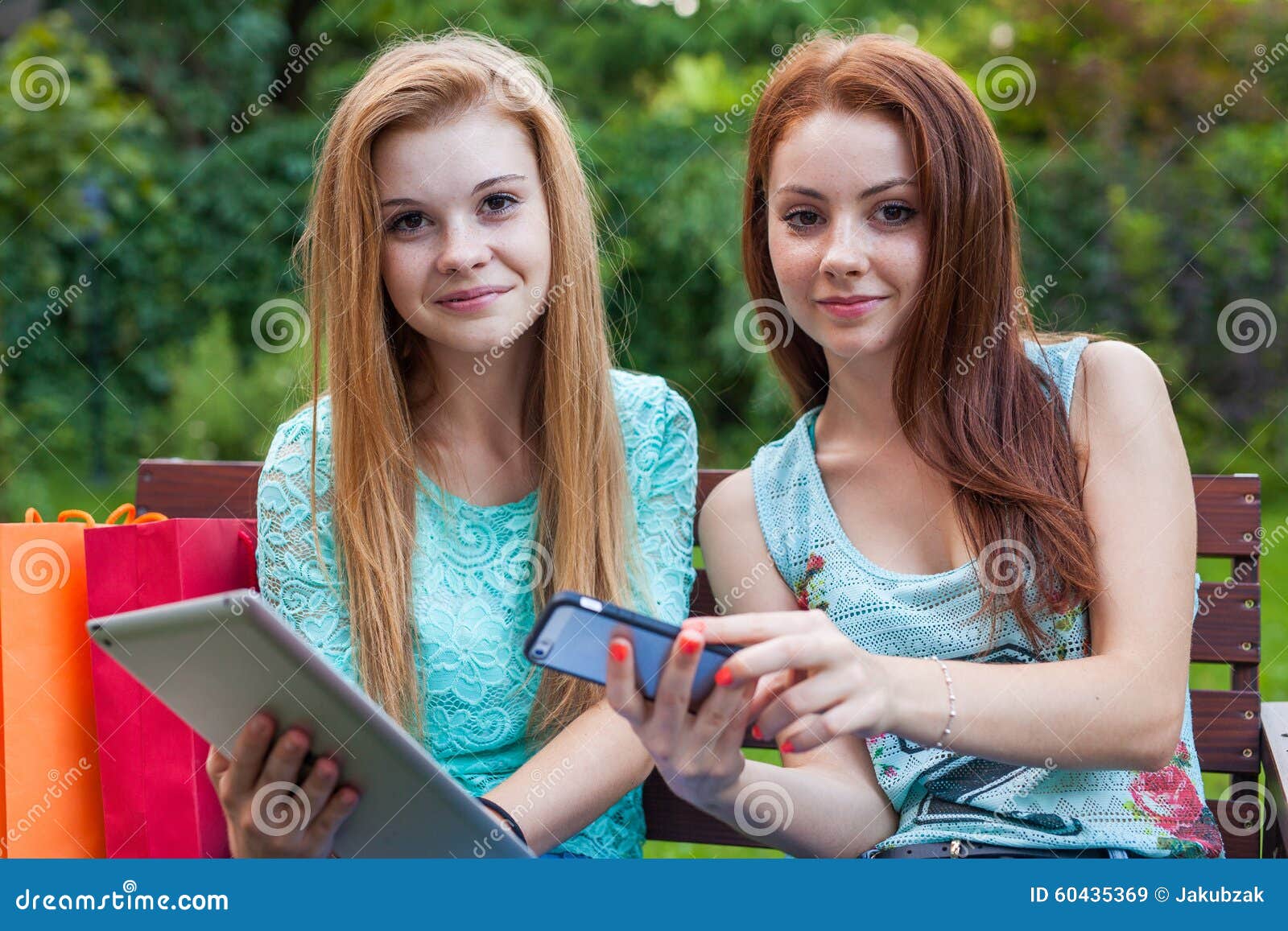 Two Pretty Young Girls Looking for New Sales Using Tablet. Stock Image Image of pretty