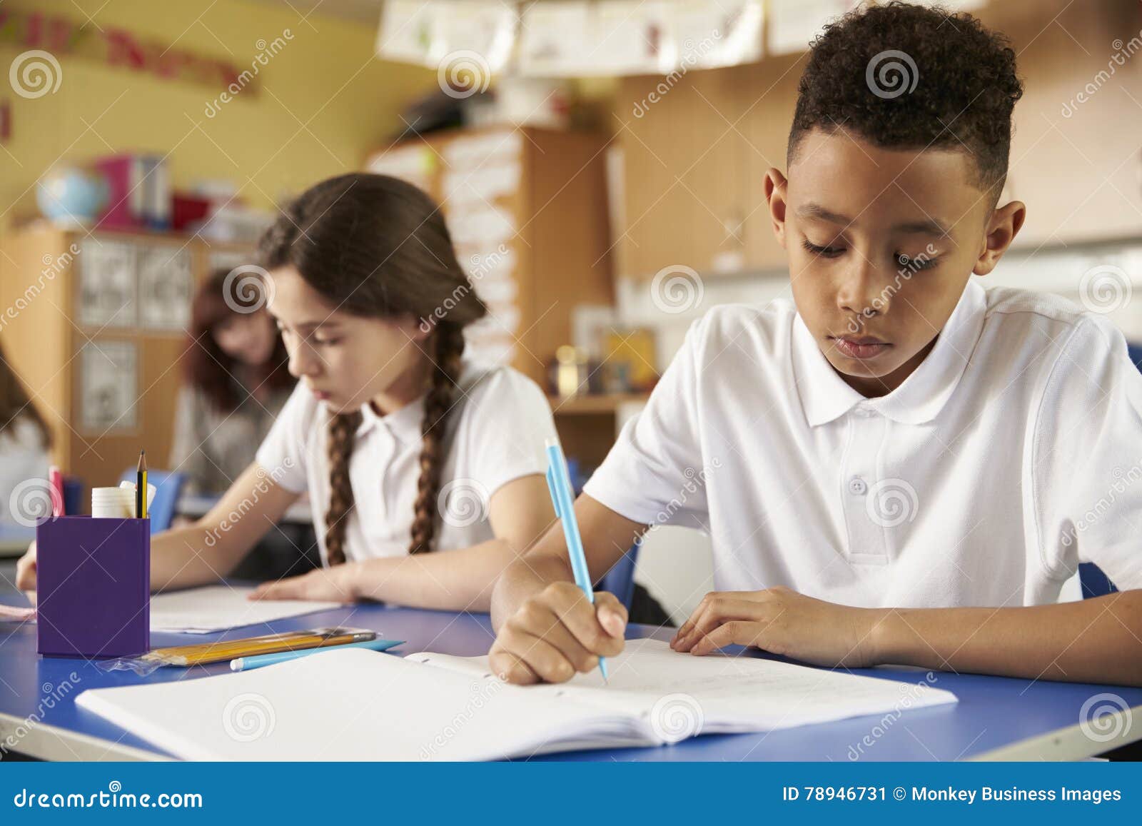 two primary school pupils at their desks in class, close up