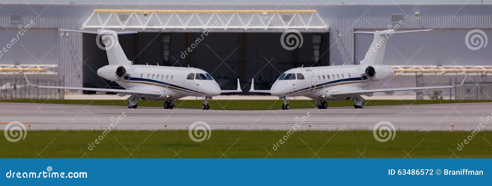 two private planes in front of a hangar