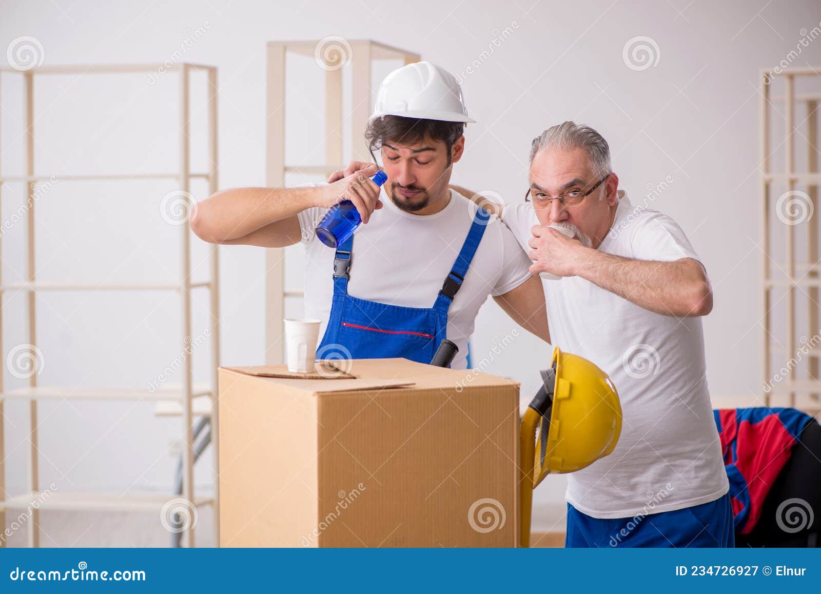 Two Male Professional Movers Drinking Alcohol during Break Stock Image