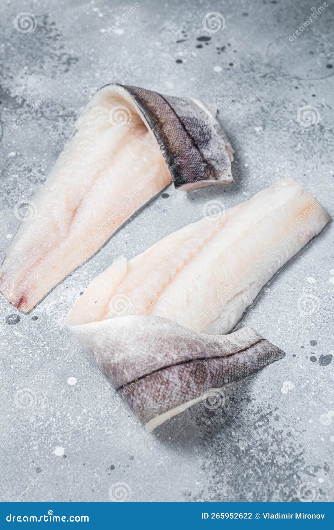 Two Raw Haddock Fish Fillets on Kitchen Table. Gray Background Stock